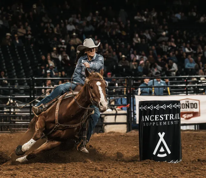 Barrel racer turning her horse in the arena