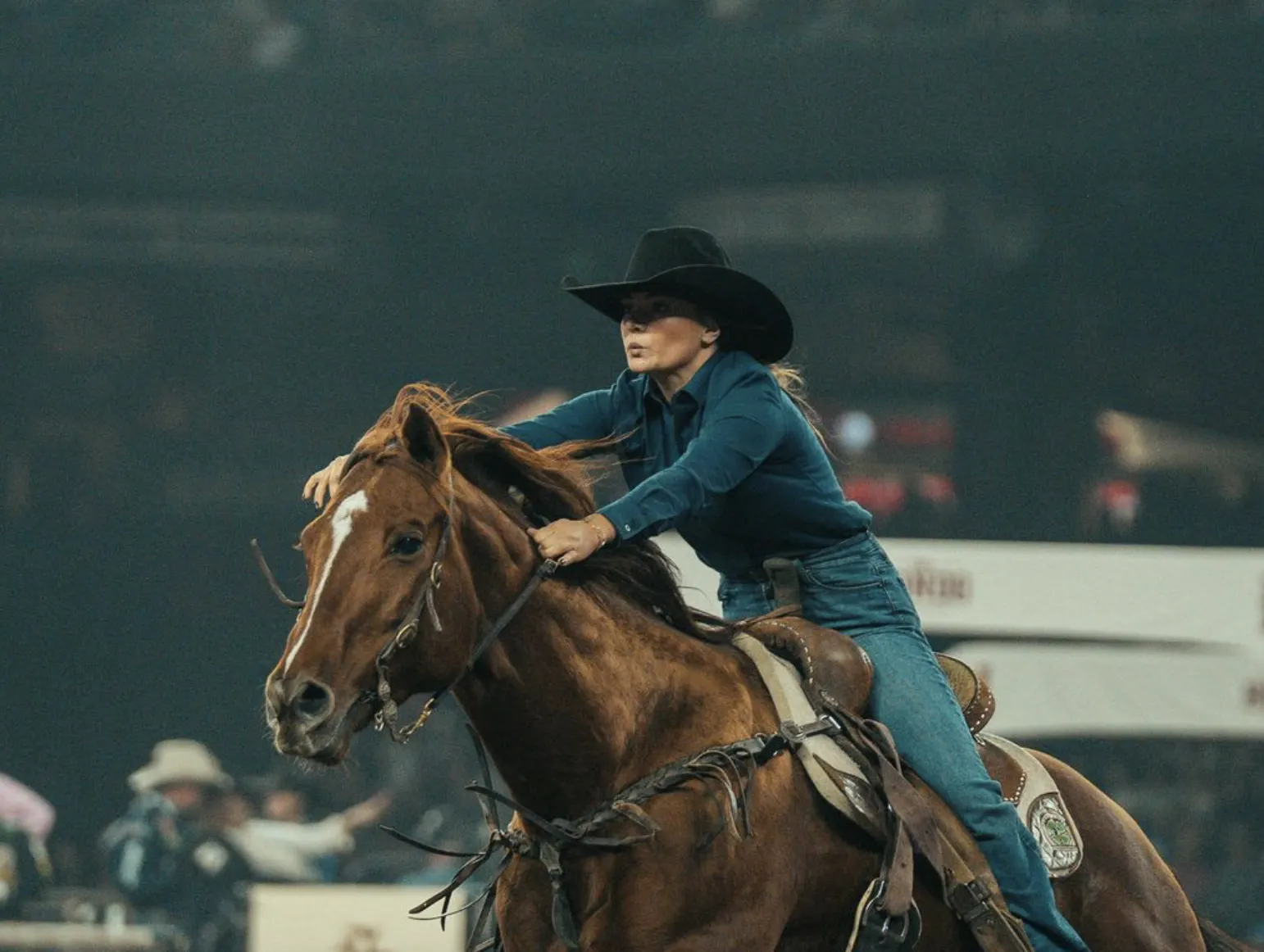 Cowgirl riding her horse in the arena