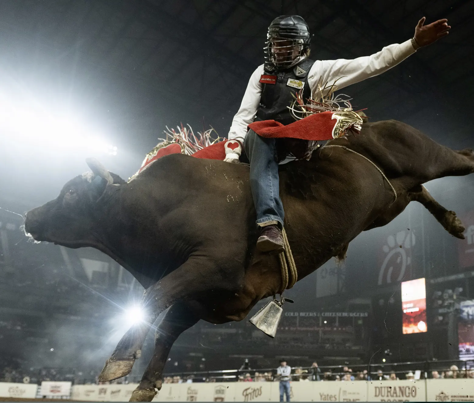 Bull rider holding on during a ride