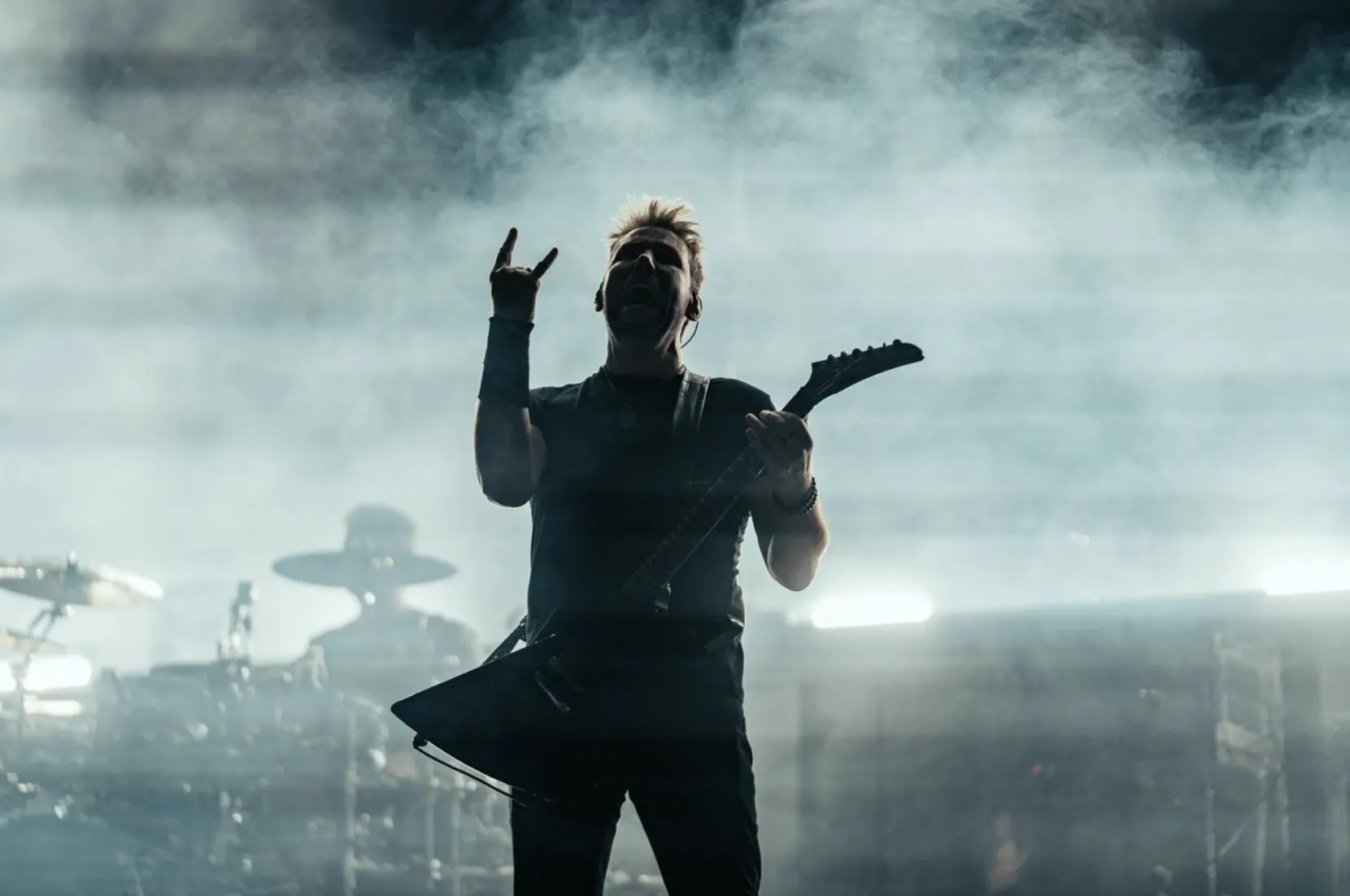 Performer silhouetted in stage fog and lights