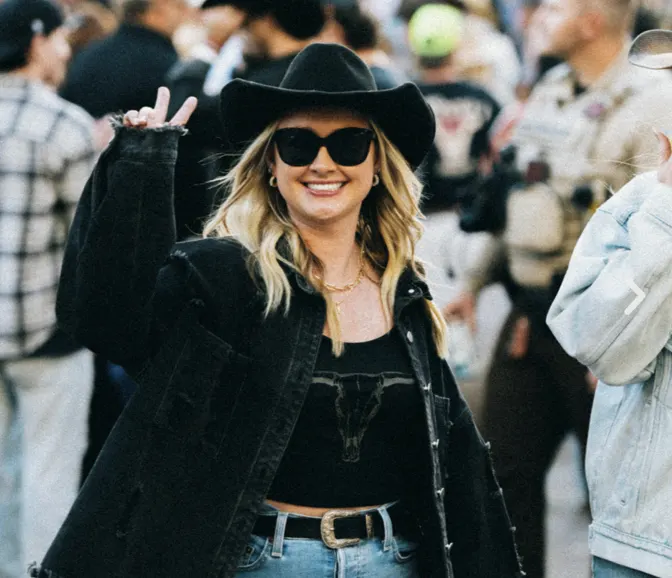Fan in a black cowboy hat and sunglasses in the crowd